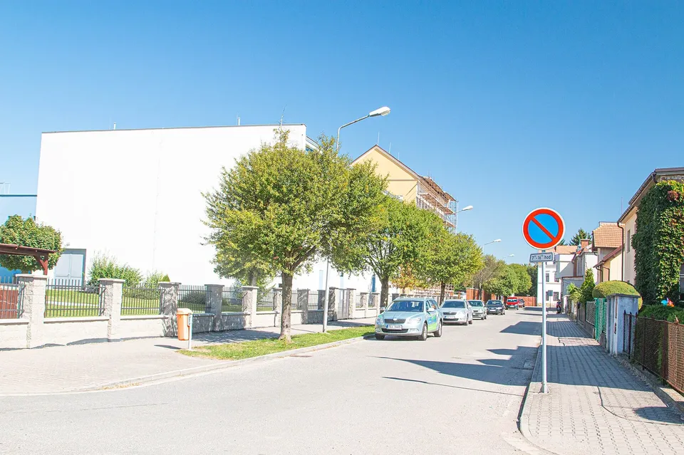Tyršova ulice, vlevo bílá stavba sportovní haly, za ní budova školy v lešení při velké opravě